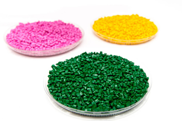 das Kunststoffgranulat. Farbstoff für Polypropylen, Polystyrol-Granulat in einen Messbehälter - Foto, Bild