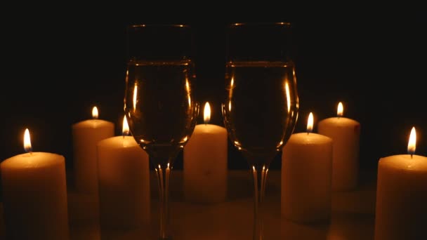 Two glasses of champagne with candles on black background - Filmagem, Vídeo