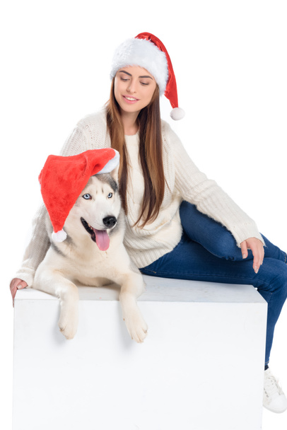 husky dog and beautiful woman in santa hats, isolated on white - Fotoğraf, Görsel
