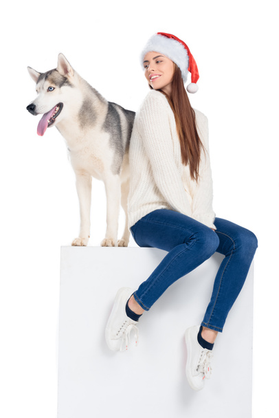Husky kutya és egy gyönyörű nő santa kalap, elszigetelt fehér - Fotó, kép