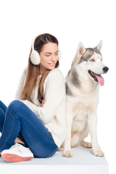 husky dog and beautiful smiling girl in winter earmuffs, isolated on white - Photo, Image