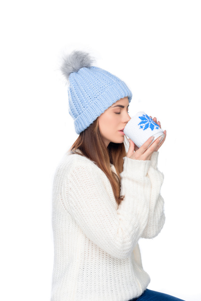 hermosa mujer en sombrero de punto y suéter de invierno beber café, aislado en blanco
  - Foto, imagen