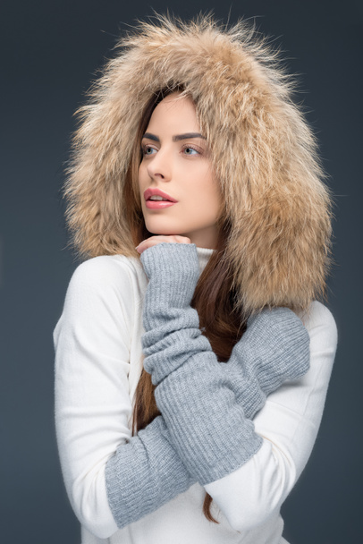 красивая женщина в меховой шапке и зимнем наряде, изолированная на сером
 - Фото, изображение