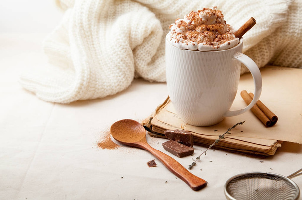 Cup of cocoa with cinnamon, whipped cream and chocolate. Textile background. Scandinavian winter concept. Horizontal composition with copy space. - Photo, Image