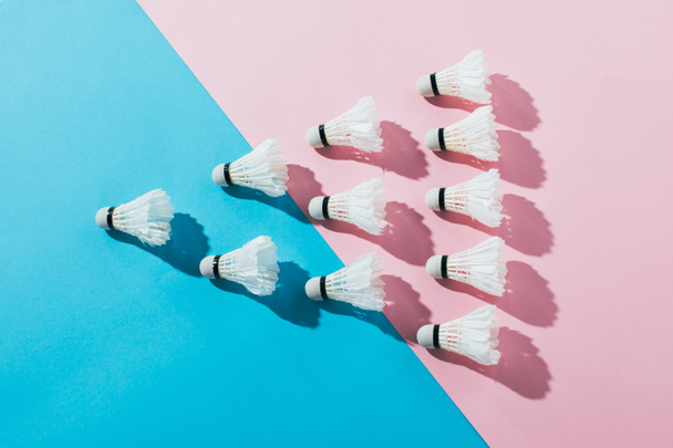 top view of composition with badminton shuttlecocks on blue and pink - Foto, Imagen
