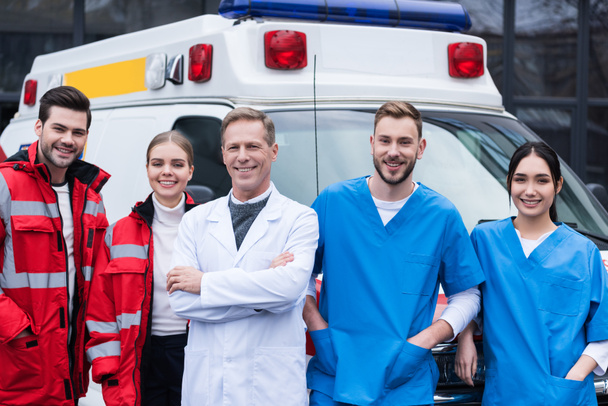 щасливі лікарі швидкої допомоги, робоча команда, що стоїть перед автомобілем
 - Фото, зображення