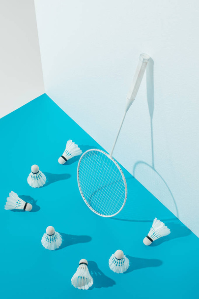 badminton racket and shuttlecocks on blue paper at white wall  - Photo, Image