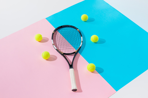 tennis racket and yellow balls on blue and pink papers - Fotoğraf, Görsel