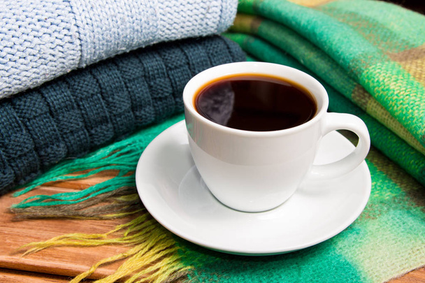 Rahat örme sıcak kazak yığını ve bir eşarp. Kazak retro tarzı ve bir fincan kahve. Sıcaklık ve konfor kavramını. - Fotoğraf, Görsel