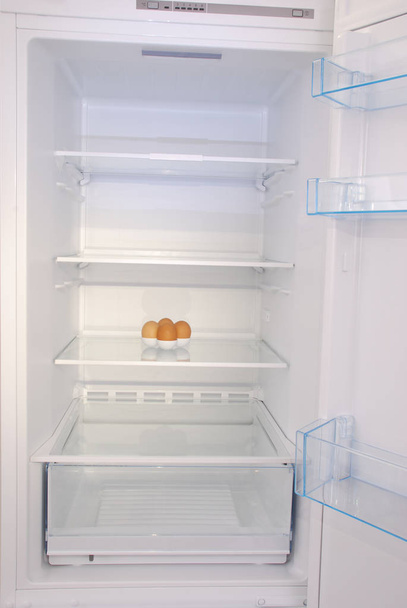 Un huevo en el refrigerador vacío abierto
. - Foto, Imagen