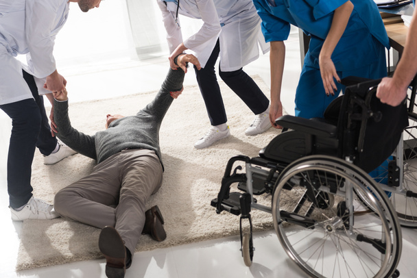 cropped image of doctors helping unconscious man in a hospital - Fotografie, Obrázek