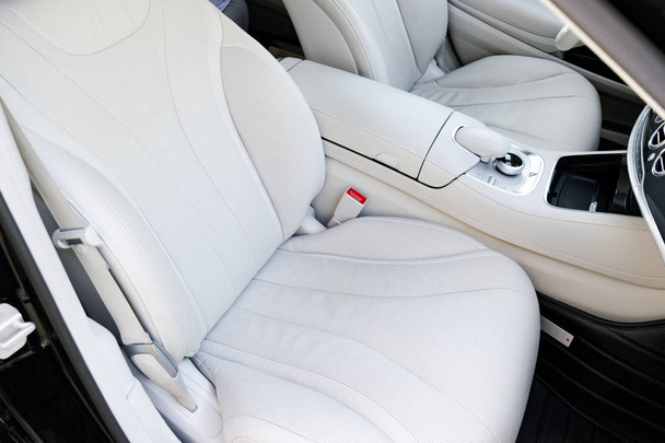 White leather interior of the luxury modern car. Leather comfortable white seats and multimedia. Steering wheel and dashboard. automatic gear stick. - Foto, afbeelding
