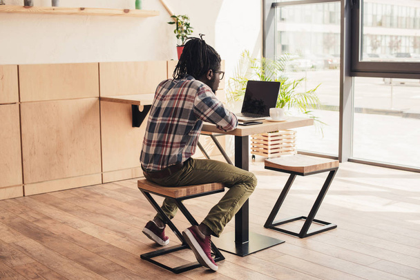 kafede dizüstü bilgisayar kullanan Afrikalı-Amerikalı adam - Fotoğraf, Görsel