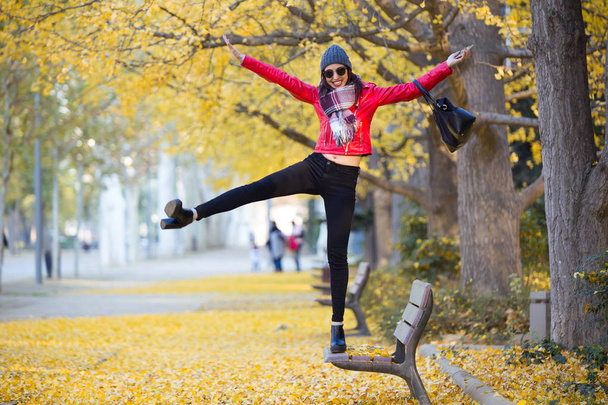 Beautiful young woman having fun in the autumn. - Фото, изображение
