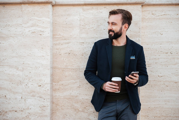 Portrait of a handsome smiling man holding coffee cup - Photo, image