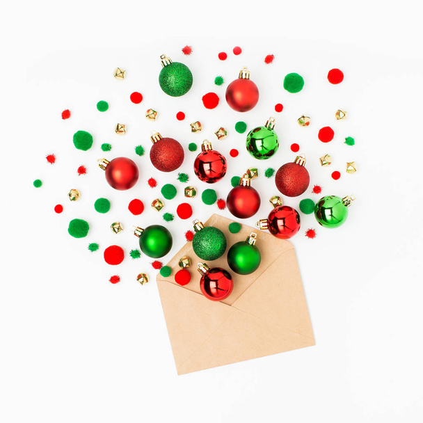  red and green Christmas balls out of envelope on white background  - Valokuva, kuva
