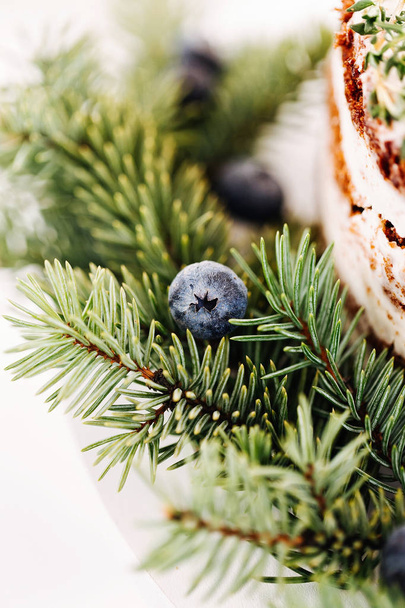 Christmas cake decorated fir branches and berries, close up - 写真・画像