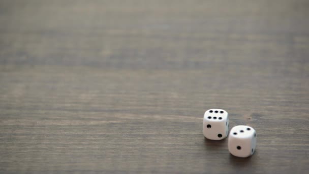 White small dices on wooden texture table - Felvétel, videó