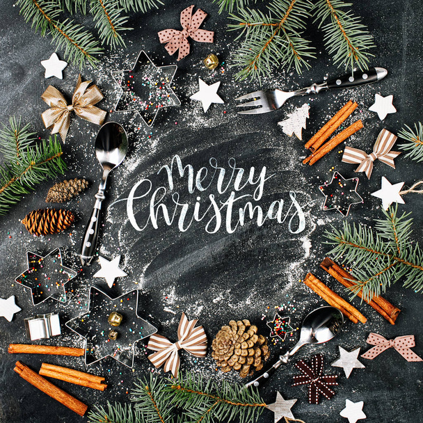 frame of fir twigs, utensils, cinnamon sticks and Christmas decorations. Merry Christmas text  - Фото, зображення