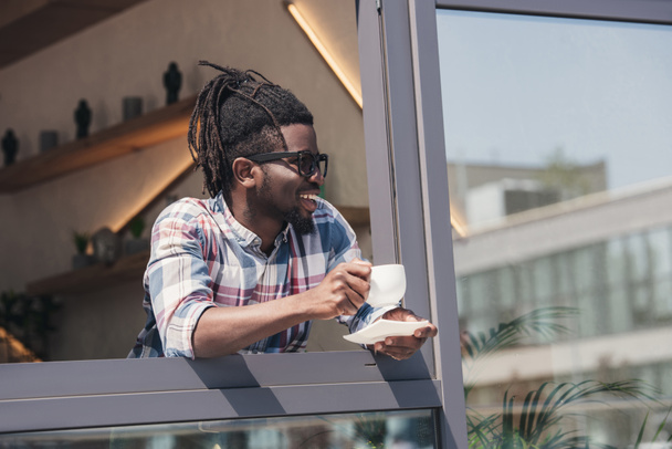 cheerful african american man drinking coffee in cafe - Foto, Imagen