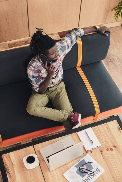az afrikai-amerikai ember használ hordozható és smartphone kávézóban felülnézeti - Fotó, kép