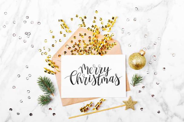blank card and envelope with beautiful Christmas decorations: fir branches, golden confetti, streamers and ball - Φωτογραφία, εικόνα