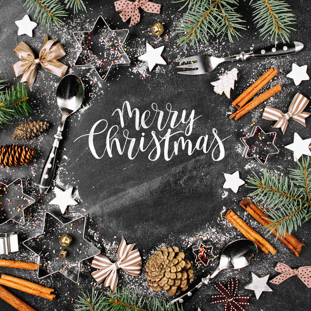 frame of fir twigs, utensils, cinnamon sticks and Christmas decorations. Merry Christmas text  - Foto, Imagen