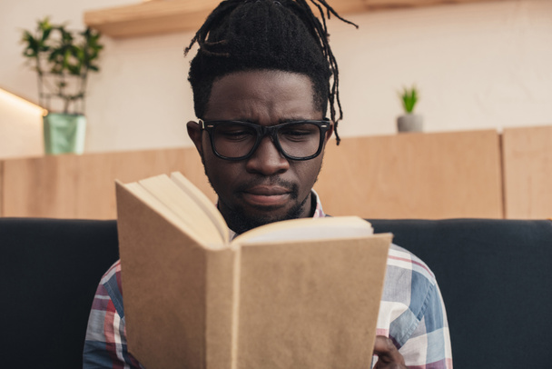 retrato del hombre afroamericano leyendo libro en la cafetería
 - Foto, Imagen