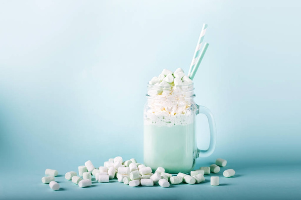 cup of delicious cocoa with marshmallows and straws on blue background - Fotografie, Obrázek
