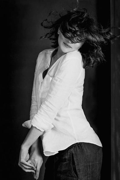 Retrato preto e branco de jovem, bela atriz sorridente com cabelo castanho curto no estúdio
 - Foto, Imagem
