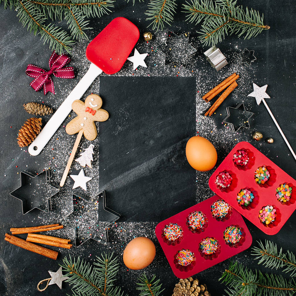 frame of Christmas treats and kitchen bakery stuff on black background with fir twigs - Foto, afbeelding