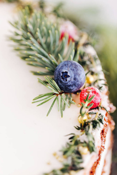 Christmas cake decorated fir branches and berries, close up - Φωτογραφία, εικόνα