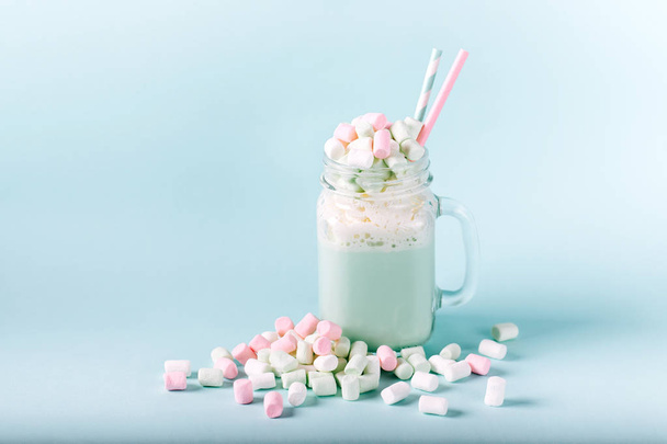 cup of delicious cocoa with marshmallows and straws on blue background - Valokuva, kuva