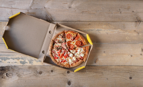 Пицца в коробке для доставки на деревянный стол
 - Фото, изображение