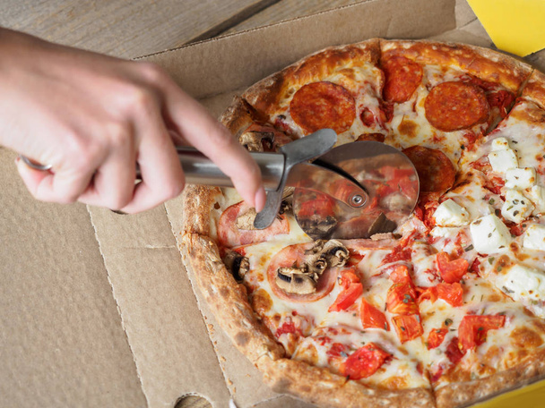 Pizza in delivery box on wooden table - Foto, imagen