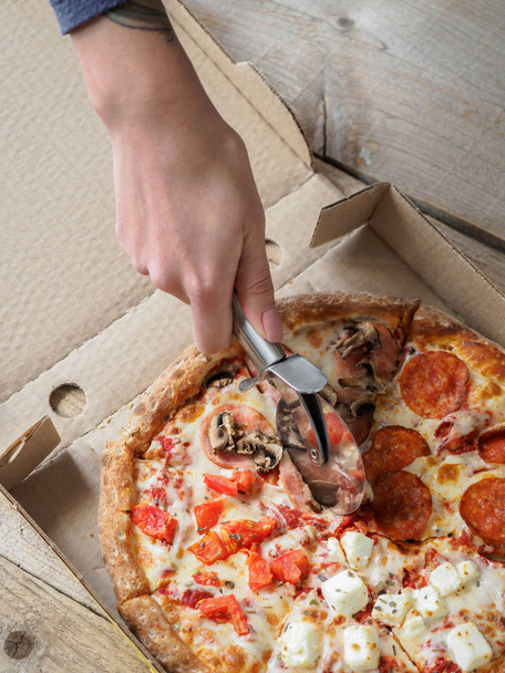 Pizza in delivery box on wooden table - Fotografie, Obrázek