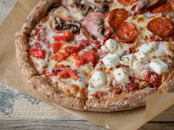 Domácí pizza nastavena na papíře na dřevěný stůl - Fotografie, Obrázek