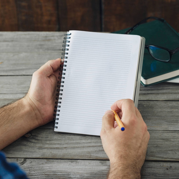 Man writes in a notebook  - Фото, изображение