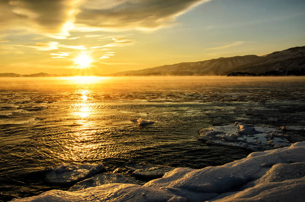 A Bajkál-tó köd vízen úszó jégtáblák. Naplemente - Fotó, kép