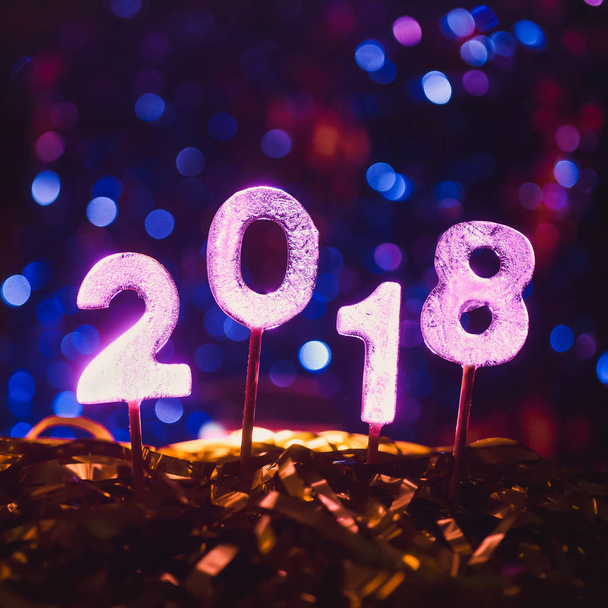 número 2018 de figuras heladas sobre un fondo de brillantes luces borrosas celebrando el año nuevo y la Navidad
 - Foto, Imagen