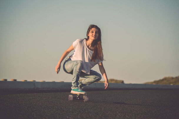 Young woman with skateboard - Foto, afbeelding