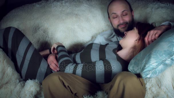Mujer embarazada feliz con marido sentado en el sofá
 - Metraje, vídeo