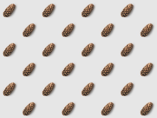 repetitive pattern of pine cones on white surface - Photo, Image