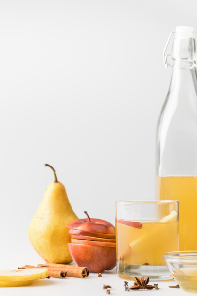 Apfelwein in Flasche mit Glas und Früchten auf weißer Oberfläche - Foto, Bild