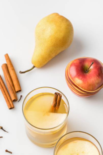 Nahaufnahme von köstlich gewürztem Cider mit Apfel und Birne auf weißer Oberfläche - Foto, Bild