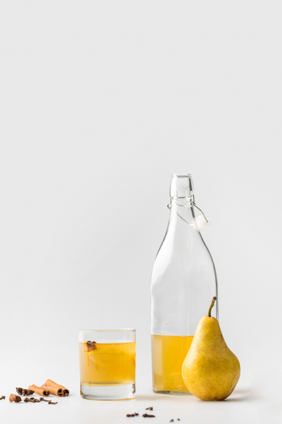 botella de sidra de pera con canela y anís sobre blanco
 - Foto, imagen