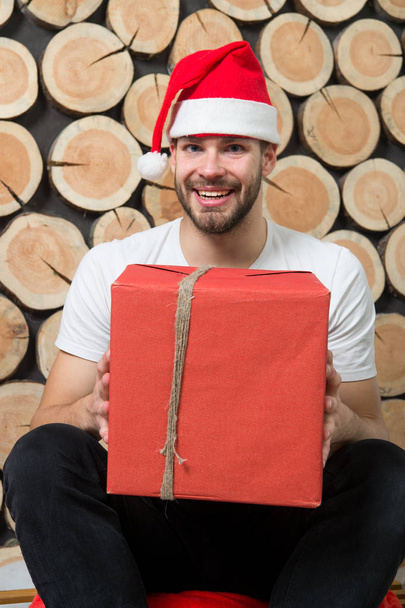 Macho in red hat smile with gift - Foto, Imagem