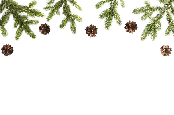 Χριστουγεννιάτικο φόντο με έλατα κλαδιά και κουκουνάρια σε λευκό φόντο - Φωτογραφία, εικόνα