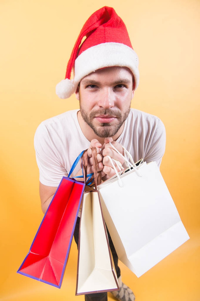 Man shopper in santa hat with paperbags - Foto, immagini