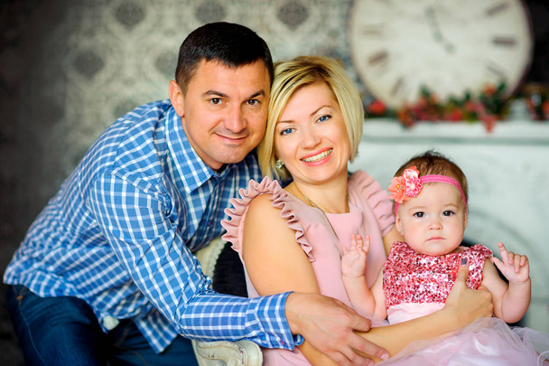 happy family in their home, parents hug their baby and smil - Fotó, kép